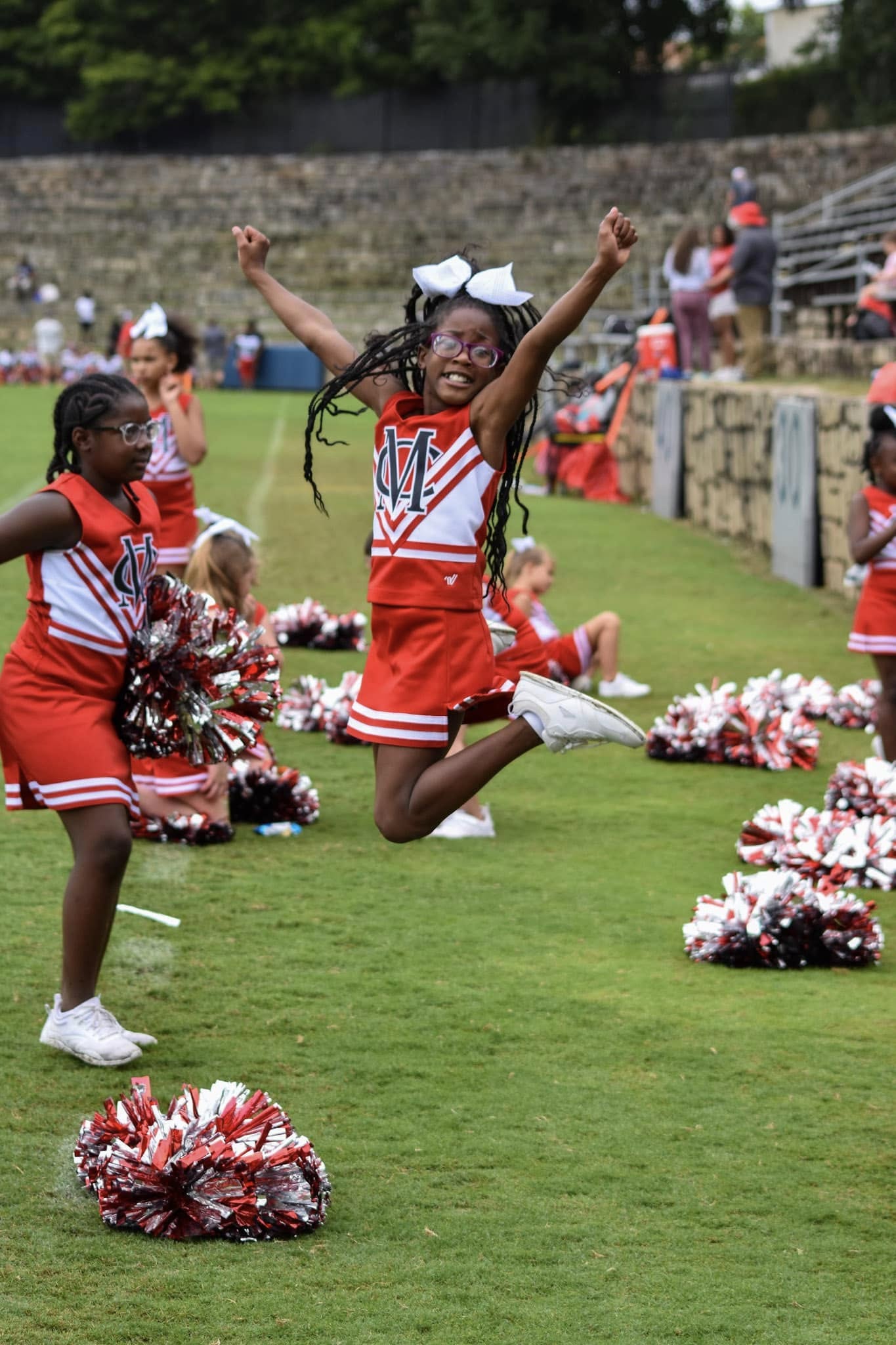 480896363_1005512321635612_979244692508904893_n1 Cheerleader jumping in the air with pom poms